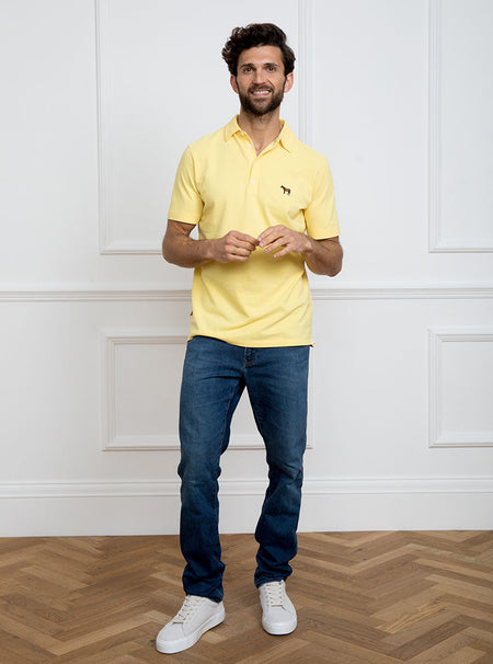 Man wearing lemon yellow polo shirt in 100% cotton with Newmarket 875 horse logo embroidered on the front.